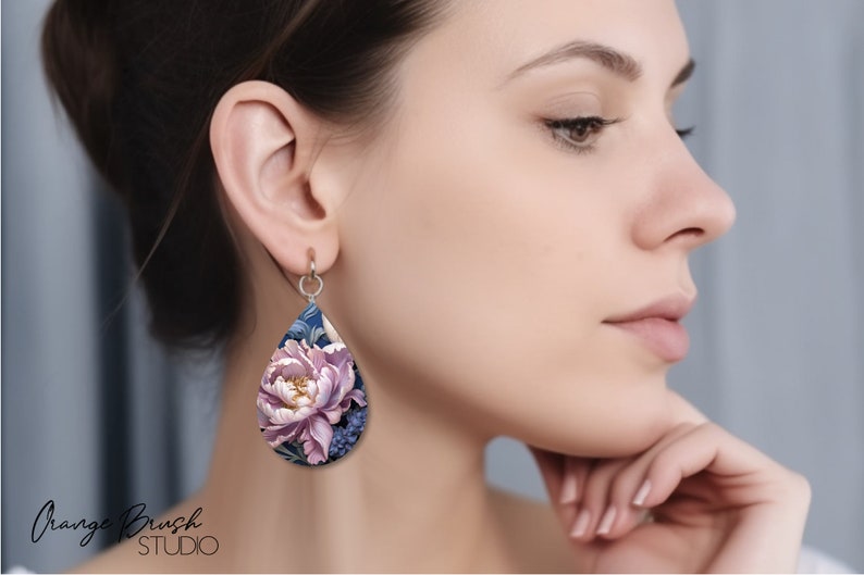 May include: A pair of teardrop-shaped earrings with a floral design. The earrings are made of polymer clay and feature a pink peony flower with blue and green leaves. The earrings are a beautiful and unique piece of jewelry.