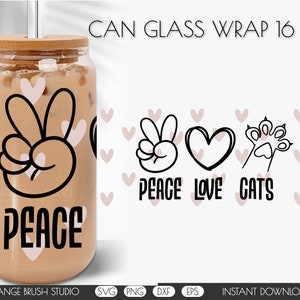 Könnte beinhalten: Ein 473 ml Glas-Dosen-Ummantelung mit einem Peace-Zeichen, Herz und Pfotenabdruck-Design. Der Text "Peace Love Cats" ist unter dem Design gedruckt. Die Ummantelung ist mit rosa Herzen verziert.