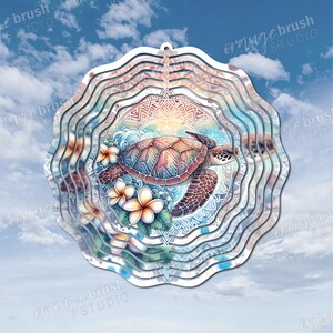 May include: A layered metal wind spinner featuring a sea turtle design. The turtle has a patterned shell and is surrounded by flowers and waves. The background includes a blue sky with clouds and the text "orange brush STUDIO".