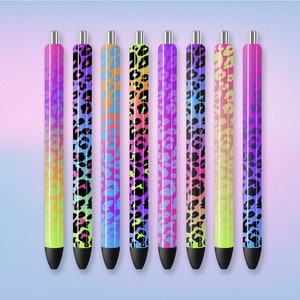 May include: Seven colorful pens with a leopard print design. The pens have a black ink tip and a silver clip. The pens are arranged in a row from left to right.