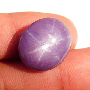 May include: A purple star sapphire gemstone with a six-pointed star in the center.