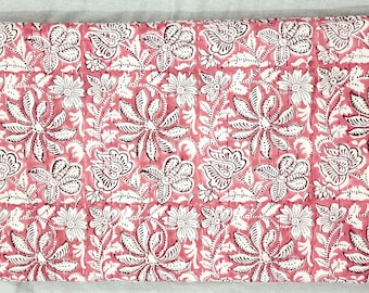 May include: Pink and white floral patterned fabric with a quilted texture. The fabric features a repeating design of stylized flowers and leaves.