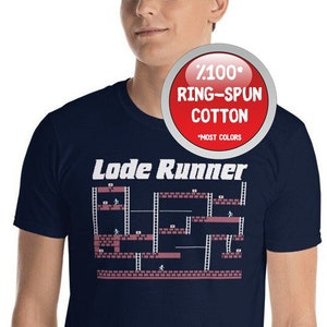 May include: A navy blue t-shirt featuring a white graphic of the classic arcade game "Lode Runner". The text "Lode Runner" is printed in white above the game graphic. The t-shirt is made from 7.1 oz ring-spun cotton.