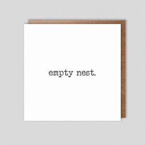 Könnte beinhalten: Eine weiße Karte mit dem Text "empty nest." in Schwarz darauf gedruckt. Die Karte liegt auf einem braunen Hintergrund.