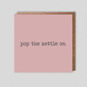 May include: A pink card with the text "pop the kettle on." printed in black.