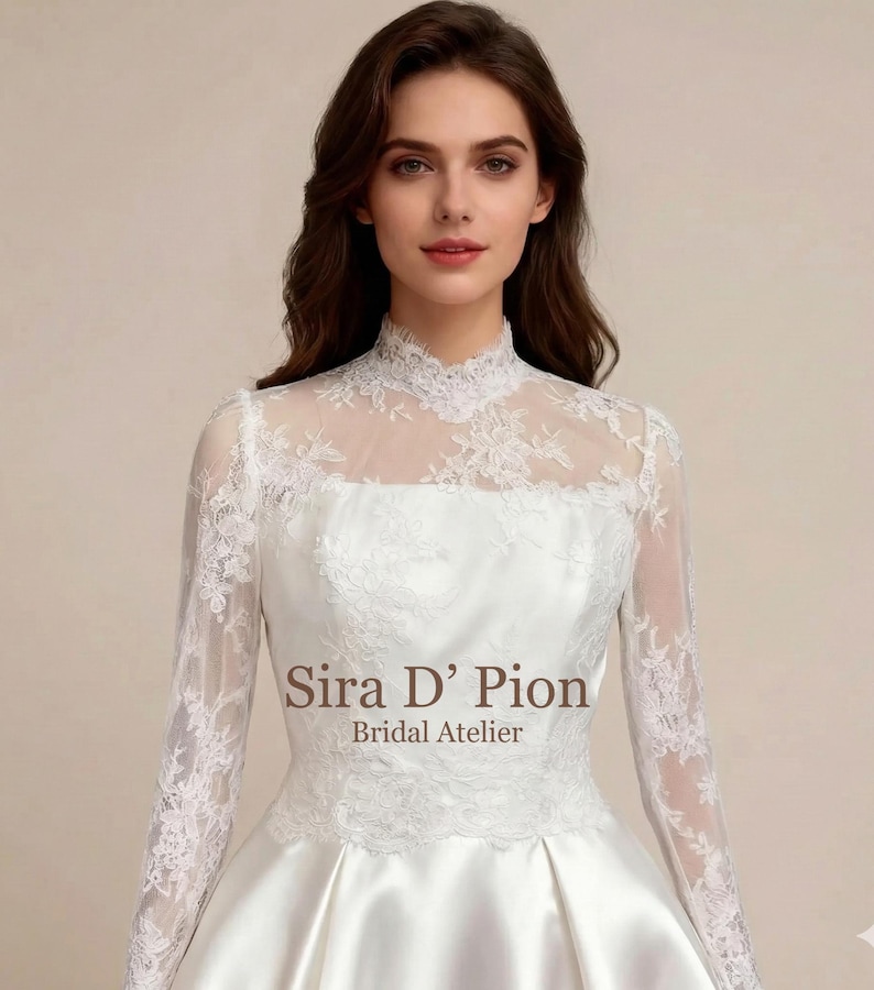 Bride wearing a long sleeve French lace bridal topper with sheer illusion neckline, floral lace embroidery, and elegant fitted styling over a white wedding gown