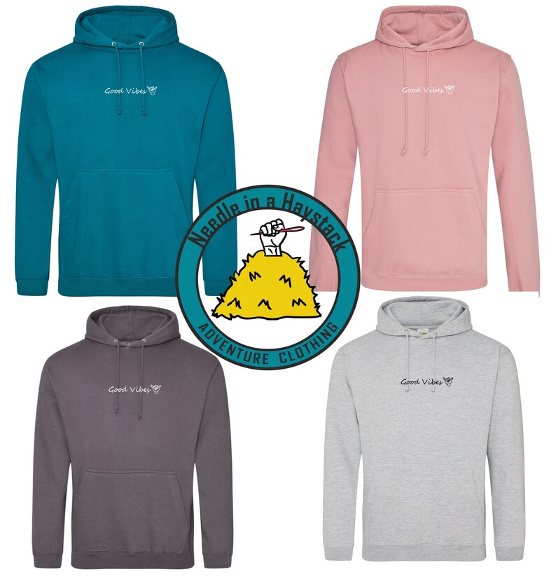May include: Five hooded sweatshirts in different colors, including teal, pink, gray, and charcoal. Each sweatshirt has the text "Good Vibes" and a small hand gesture graphic printed on the front. The sweatshirts are arranged in a circle around a logo that reads "Needle in a Haystack Adventure Clothing".