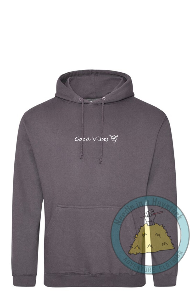 May include: A charcoal gray hoodie with a white graphic that says "Good Vibes" and a hand gesture. The hoodie has a drawstring hood and a kangaroo pocket.
