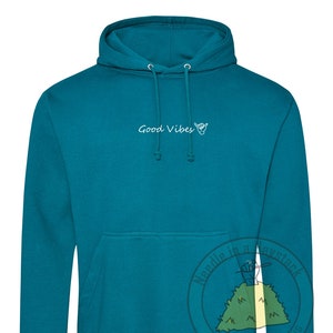 May include: Teal blue hoodie with a white graphic that says "Good Vibes" and a hand gesture.