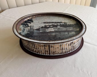 Lata vintage de galletas Sunshine de 1978 con ilustraciones nostálgicas del río Mississippi.