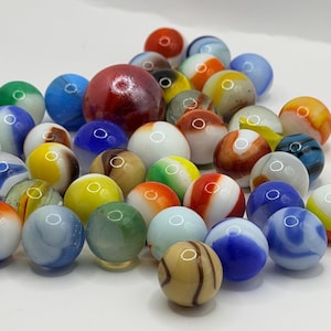 May include: A collection of colorful glass marbles in various sizes and designs. The marbles feature a mix of colors, including red, blue, green, yellow, and white, with swirled and solid patterns. Some marbles have a glossy finish.