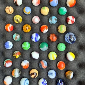 May include: A set of three ceramic mugs with a speckled, matte finish in cream, light grey, and dark grey. Each mug has a simple, minimalist design, suitable for coffee or tea.