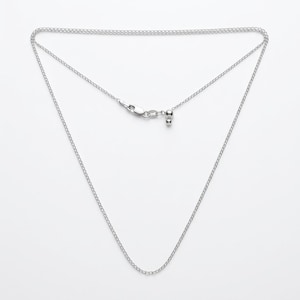 May include: A silver-toned chain necklace featuring a delicate link design. The necklace includes a secure lobster claw clasp and a small sliding bead mechanism for adjustable length, creating a versatile piece of jewelry.