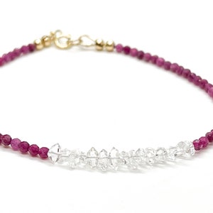 Puede incluir: Un brazalete delicado con un diseño de dos tonos. El brazalete está hecho con pequeñas cuentas redondas de color rosa y una fila de cuentas transparentes facetadas en el centro.