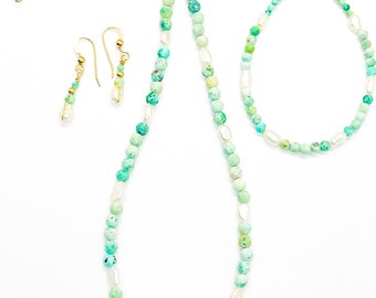 Könnte beinhalten: Ein Schmuckset aus Türkis und Perlen mit einer Halskette, einem Armband und Ohrringen. Die Halskette und das Armband bestehen aus kleinen, facettierten Türkisperlen und weißen Perlen. Die Ohrringe sind einfache Ohrhänger mit einer einzelnen Türkisperle.