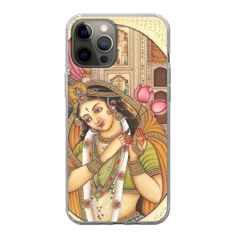 Pode incluir: Capa de telefone transparente com uma ilustra&ccedil;&atilde;o detalhada de uma mulher em trajes tradicionais indianos. A obra de arte mostra uma mulher com joias, segurando flores de l&oacute;tus rosa. O fundo inclui detalhes arquitet&ocirc;nicos.