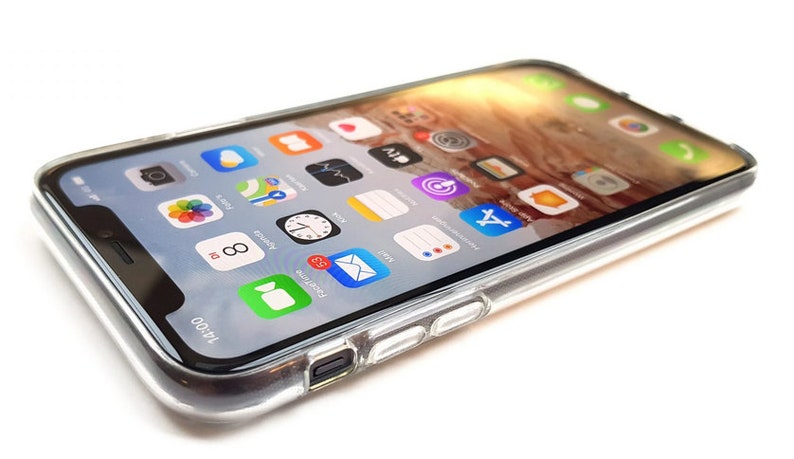 Puede incluir: Una funda transparente para tel&eacute;fono con un iPhone negro en su interior. La pantalla del tel&eacute;fono muestra una variedad de iconos de aplicaciones, incluyendo las aplicaciones de c&aacute;mara, reloj y correo. La hora en el tel&eacute;fono es las 14:00.