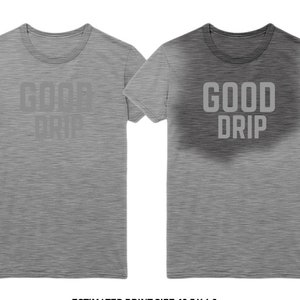 May include: Two heather gray short-sleeve t-shirts featuring the text GOOD DRIP in a block font. The left shirt has a subtle print, while the right shirt displays the same text with a dark, smoky, circular gradient effect surrounding the lettering.