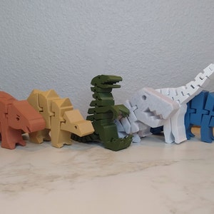 May include: A set of six colorful dinosaur toys made of plastic. The dinosaurs are in various poses, including standing, walking, and running. The dinosaurs are all different colors, including red, brown, green, white, and blue.