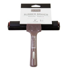 May include: A 6-inch (15.2 cm) black rubber brayer with a brown plastic handle. The handle has the text "re-design" printed on it. The brayer is used for applying paint, ink, or other materials to surfaces.