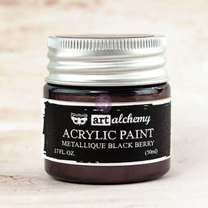May include: A small jar of Art Alchemy acrylic paint in Metallique Black Berry. The jar has a silver lid and a black label with white text. The paint is .17 fl oz (50ml).