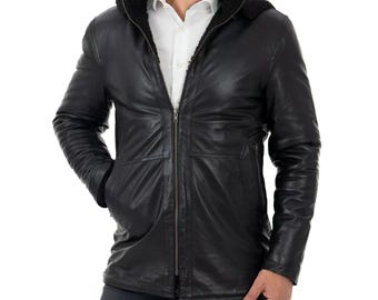 May include: A black leather jacket with a hood lined with black faux fur. The jacket has a zipper closure and two front pockets. The model is wearing a white button-down shirt underneath. The jacket appears to be a medium length.