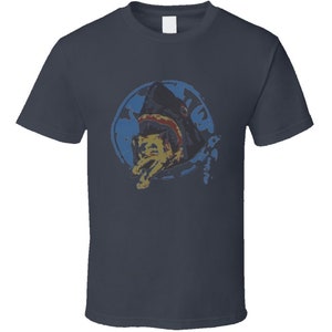 May include: A navy blue t-shirt with a graphic of a shark biting a fish. The graphic is in a blue, yellow, and red color scheme.