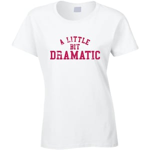 May include: White t-shirt with a pink graphic that says "A Little Bit Dramatic".
