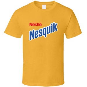 Puede incluir: Una camiseta amarilla con el logotipo de Nestle Nesquik en letras azules y rojas.