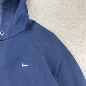 May include: A navy blue hooded sweatshirt with a white Nike swoosh logo on the front.