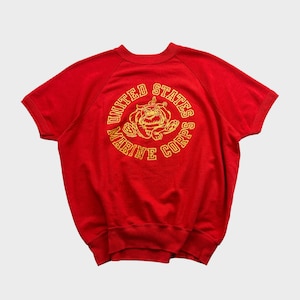 May include: Red short-sleeved sweatshirt with a yellow embroidered circle graphic that says "United States Marine Corps" with a bulldog inside the circle.