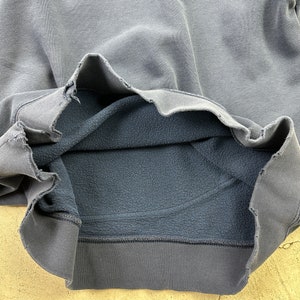 May include: A dark gray sweatshirt with a fleece lining. The sweatshirt is turned inside out to show the lining.