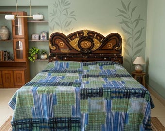 Könnte beinhalten: Ein Bett mit einer Patchwork-Decke in Blau- und Grüntönen. Die Decke hat eine Mischung aus gestreiften und karierten Mustern. Das Kopfteil ist aus dunklem Holz mit goldenen Akzenten. Der Raum hat eine hellgrüne Wand und ein Holzregal.