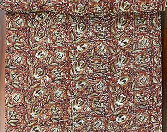Puede incluir: Una colcha kantha roja y marrón con un patrón floral. La colcha está hecha de algodón y está cosida a mano.