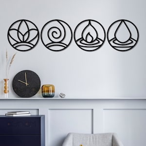 May include: Four black metal wall decor circles with different designs. The designs are a lotus flower, a spiral, a flame, and a water drop. The circles are hanging on a white wall above a blue cabinet and a grey chair with a yellow cushion.
