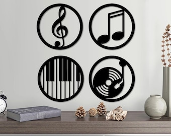 May include: Four black metal wall decor pieces with musical symbols. The symbols include a treble clef, a musical note, a piano keyboard, and a record player.