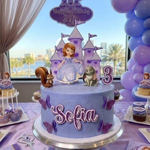 May include: A lavender birthday cake with the name "Sofia" in purple script, adorned with butterfly decorations. The cake features a princess and castle topper, with a "Happy 3rd Birthday" sign. Additional cupcakes and treats are on the table.