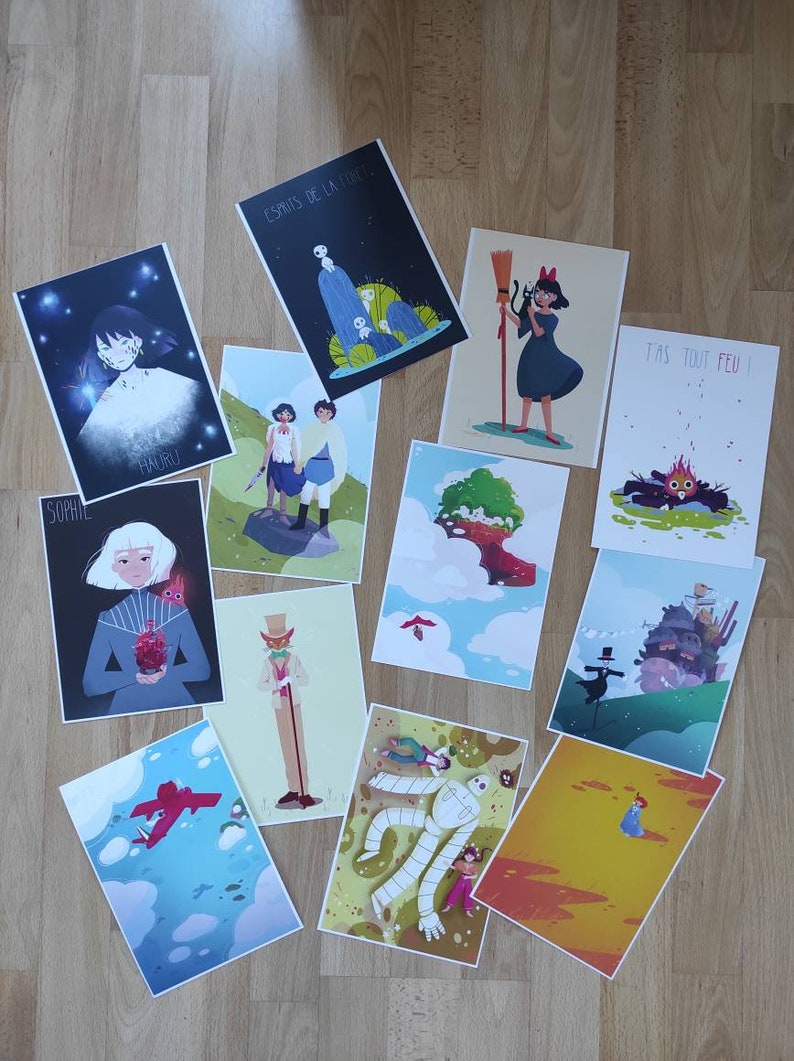 May include: A collection of 10 colorful illustrated prints featuring characters and scenes from popular animated films. The prints are arranged on a wooden surface.