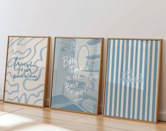 May include: Three framed art prints with light wood frames. The prints feature blue and white designs and text. One print says "Wash your problems", another says "Bath Time is the Best Time!", and the third says "Get Naked".