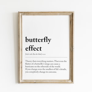 May include: A framed print with a black and white definition of the "butterfly effect". The definition reads: "Theory that everything matters. That even the flutter of a butterfly's wings can cause a hurricane on the other side of the world. If you change even the smallest of life's details, you completely change its outcome."