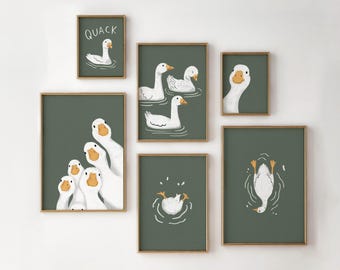 May include: A set of six framed prints featuring illustrations of white geese on a green background. The prints have gold frames and include the text "QUACK".