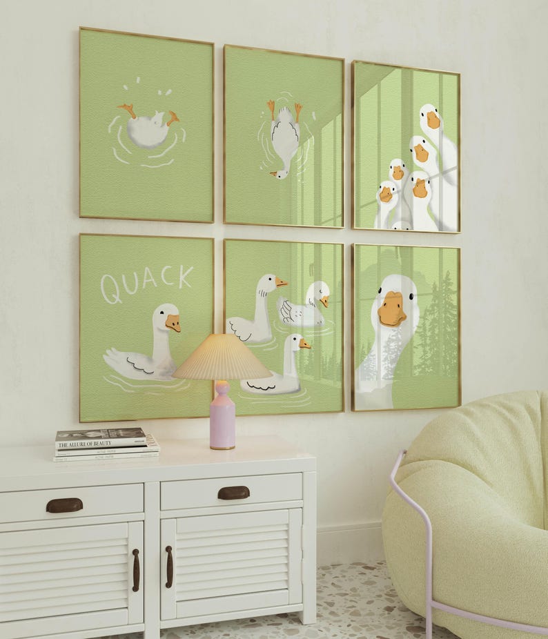 Puede incluir: Un conjunto de seis impresiones enmarcadas con ilustraciones de patos blancos sobre un fondo verde claro. Las impresiones est&aacute;n dispuestas en una cuadr&iacute;cula en una pared blanca. La fila superior presenta un pato buceando en el agua, un pato boca abajo y un grupo de patos mirando al espectador. La fila del medio presenta un pato nadando con el texto "QUACK" encima, un grupo de patos nadando y un pato nadando con la cabeza fuera del agua. La fila inferior presenta un pato nadando con la cabeza fuera del agua.
