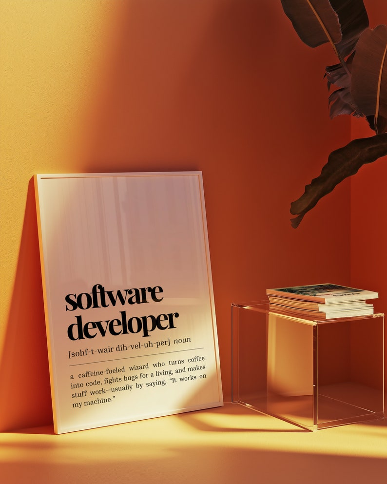 May include: A framed print with a white background and black text defining the word "software developer". The definition reads: "[sohf-t-wair dih-vel-uh-per] noun a caffeine fuelled wizard who turns coffee into code, fights bugs for a living, and makes stuff work - usually by saying, "It works on my machine."