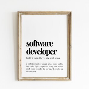 May include: A framed print with a black and white definition of a "software developer" with the pronunciation and a humorous description of the job.
