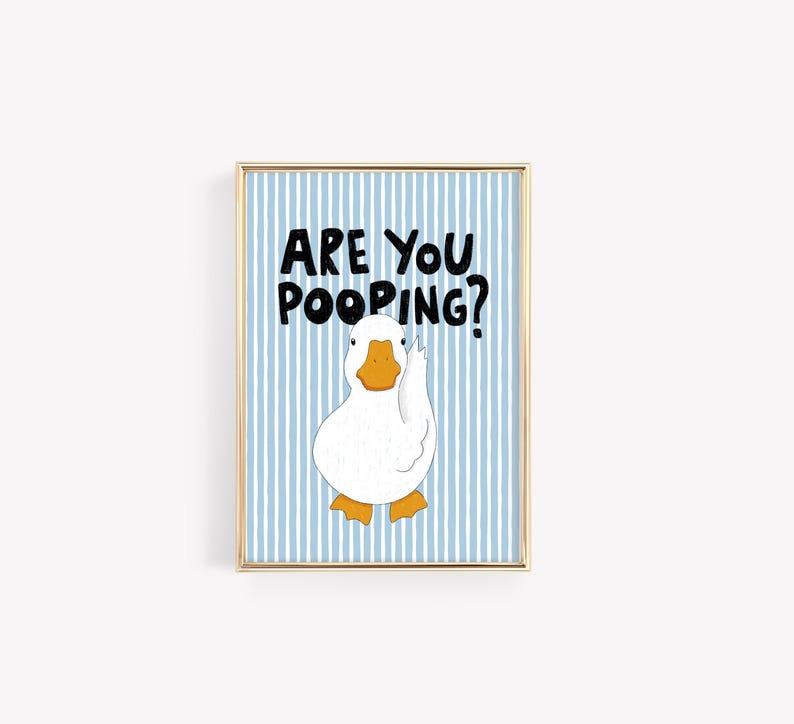 May include: A rectangular wall art print in a gold frame featuring a white duck with an orange beak and feet against a light blue and white vertical striped background. The black text above the duck reads, ARE YOU POOPING? in a bold, hand-drawn style.