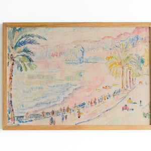 May include: A framed print of a beach scene with palm trees, people, and buildings. The artwork features a pastel color palette of pink, blue, yellow, and green. The frame is made of light-colored wood.