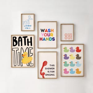 Può includere: Un set di otto stampe da bagno colorate con varie frasi e illustrazioni. Le stampe presentano un'anatra di gomma gialla, un animale di palloncino blu, una doccia e le frasi "Bath Time", "Wash Your Hands", "Let That Sit Go", "Oui Oui" e "This Shower Is For Singing".