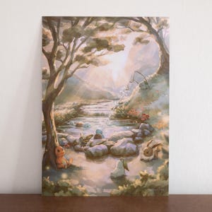 Könnte beinhalten: Ein rechteckiger Kunstdruck mit einer weichen, malerischen Landschaft, in der ein sonnendurchfluteter Bach durch einen Wald fließt. Mehrere kleine, stilisierte Kreaturen sind in der Nähe des Wassers dargestellt, darunter eine orangefarbene Echse.
