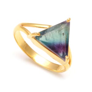 May include: A gold ring featuring a triangular green, blue, and purple gemstone.