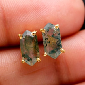 May include: A pair of gold earrings with green moss agate stones. The stones are cut in a hexagonal shape and have a natural, organic look.